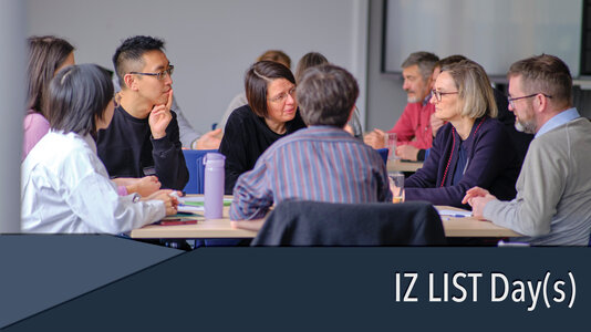 Group of scientists sitting around a table and talking to each other