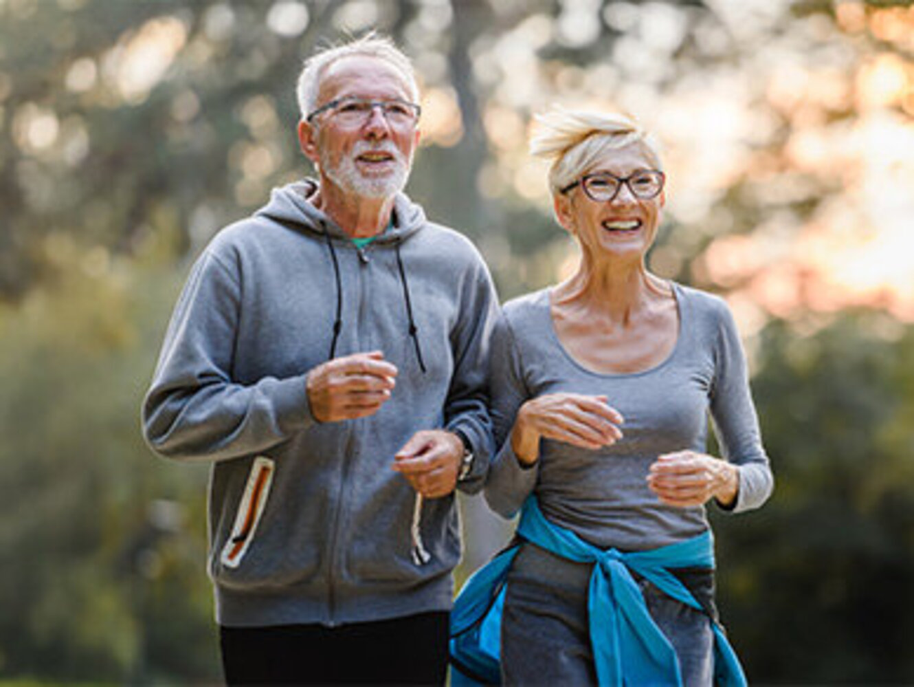 Smiling senior couple jogging in the park