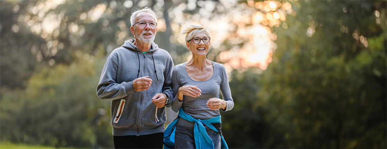 Smiling senior couple jogging in the park