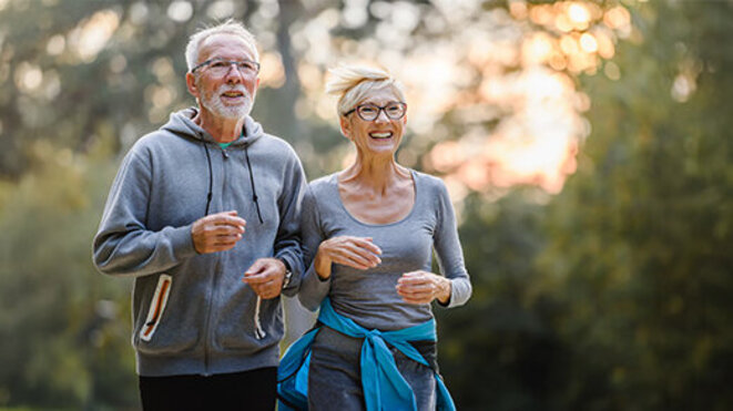 Smiling senior couple jogging in the park