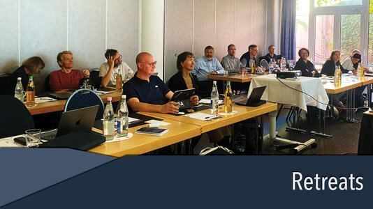 Group of people at a scientific retreat, listening to a speaker