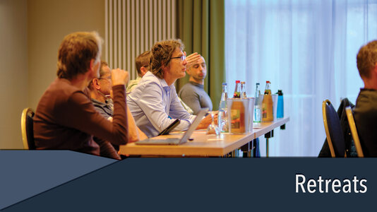 Group of people at a scientific retreat, listening to a speaker