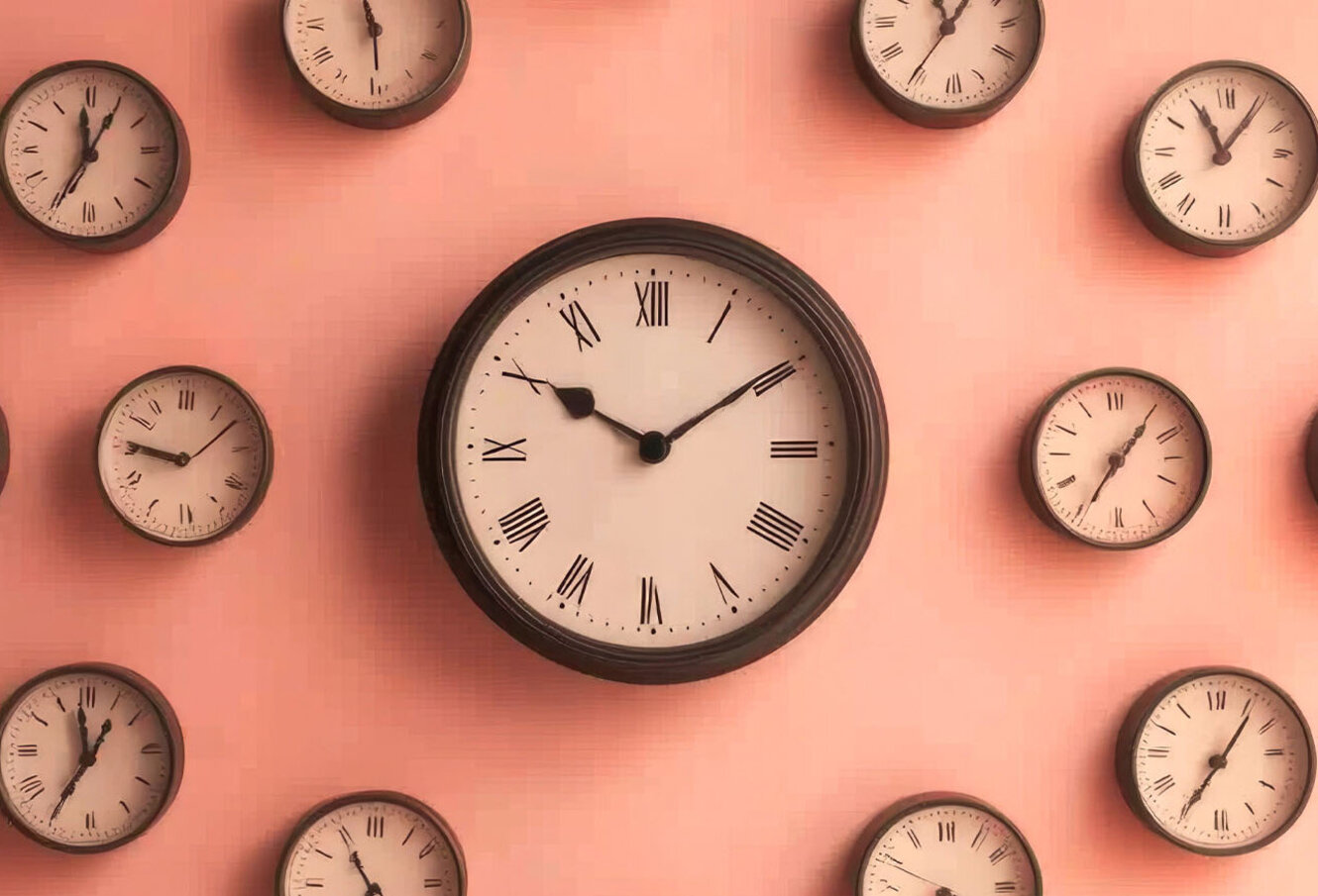 An artistic arrangement of multiple wall clocks displayed against a softly lit wall, showcasing the passage of time and vintage aesthetics