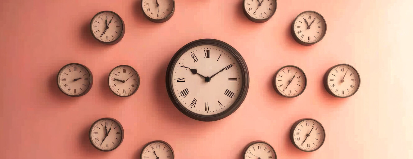 An artistic arrangement of multiple wall clocks displayed against a softly lit wall, showcasing the passage of time and vintage aesthetics