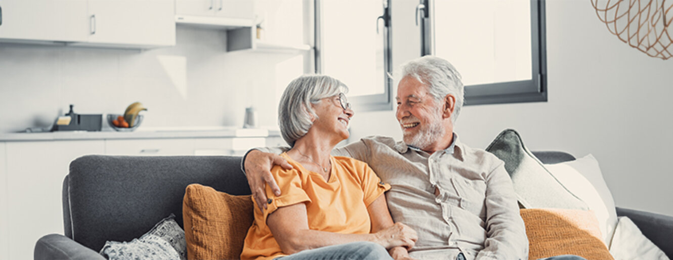 Happy older married couple smiling at each other