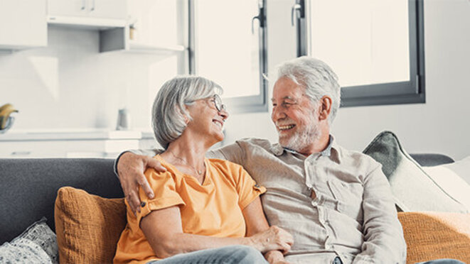 Happy older married couple smiling at each other