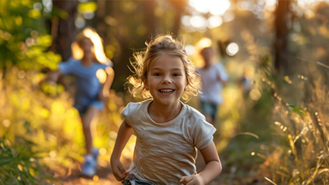 A young girl runs away from her friends in the forest at the golden hour in a spirited game of tag. AI generated