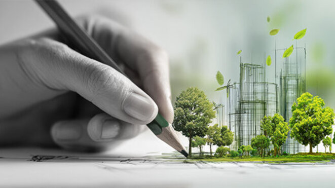A hand drawing a sustainable urban development with green trees and wind turbines. 