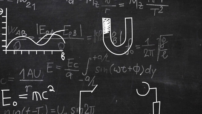 Albert Einstein Figurine in front of a Blackboard with physical formulas.