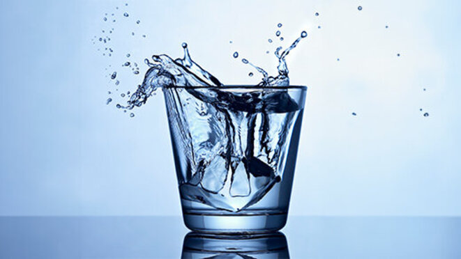 glass of water with water spilling over the edge