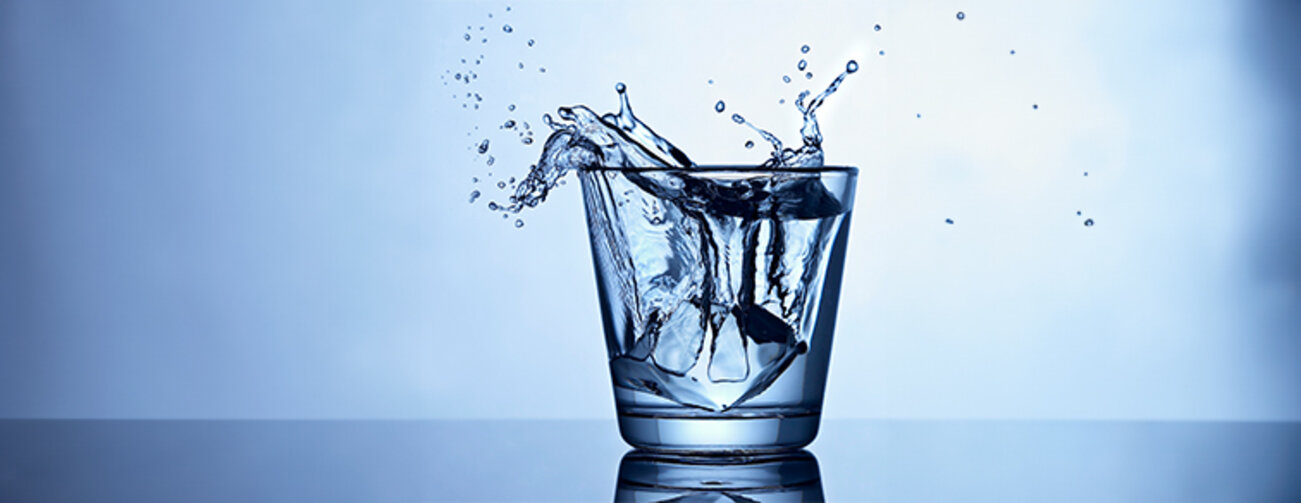 glass of water with water spilling over the edge