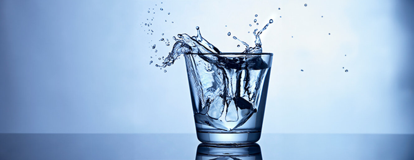 glass of water with water spilling over the edge
