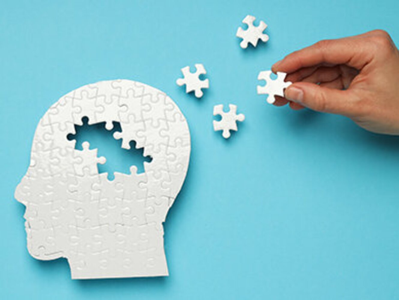 Puzzle head with missing elements on a blue background 