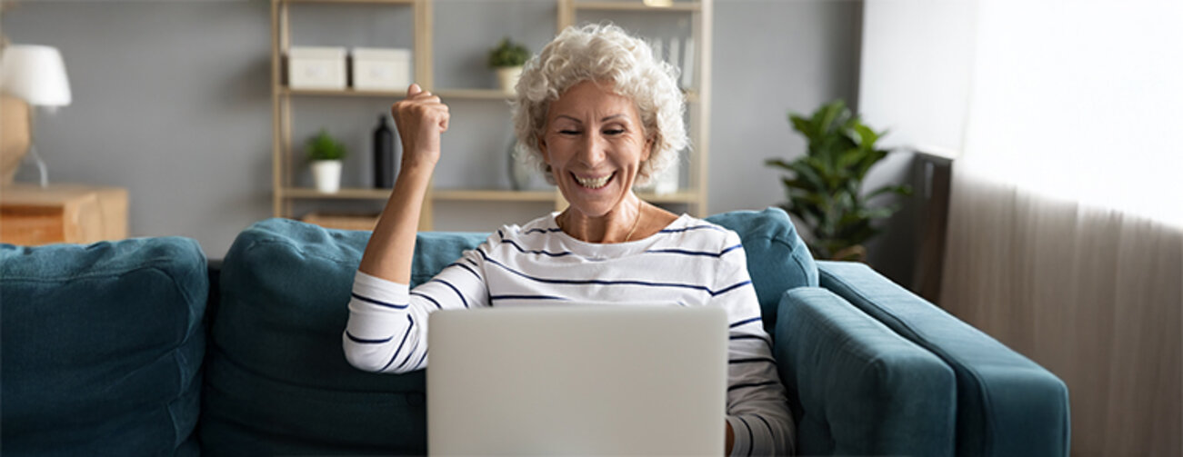 Excited aged woman feels overjoyed about achieving a goal